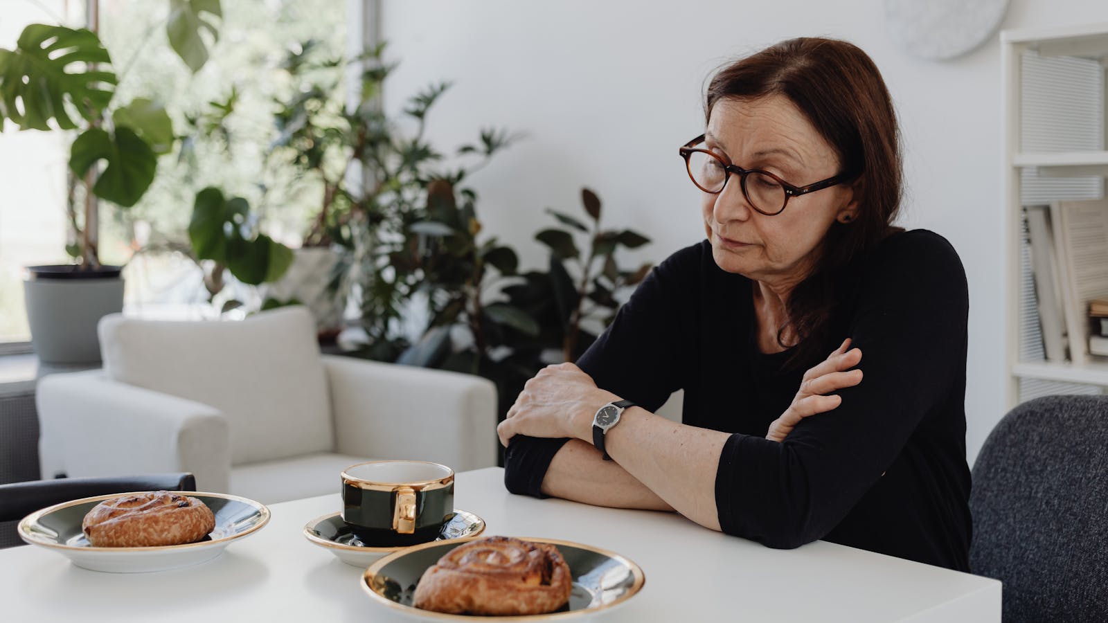 A companion and an older adult sharing tea at a kitchen table